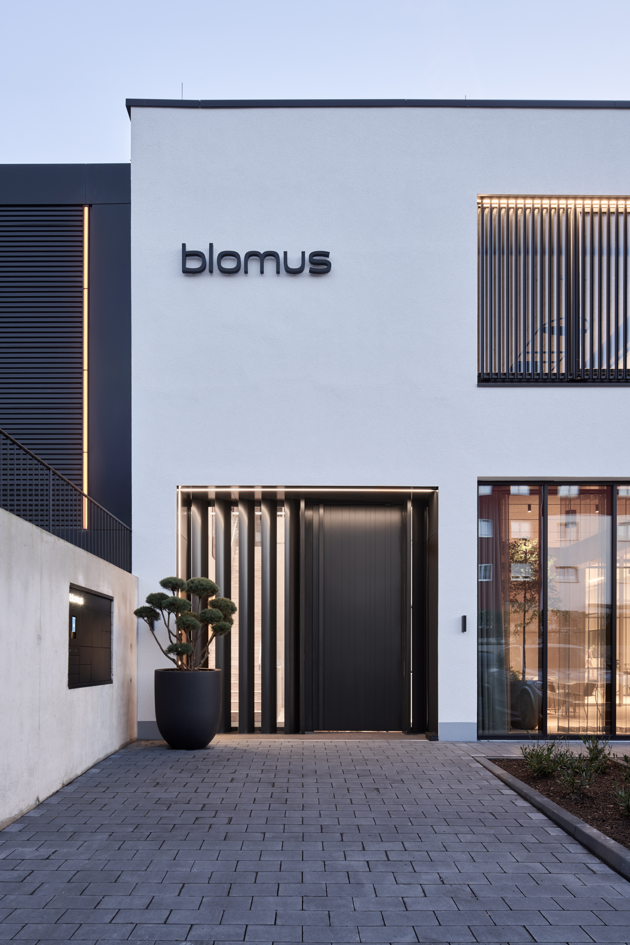 Moderne blomus Firmenzentrale mit blomus Logo an minimalistischer Gebäudefassade und Eingang
