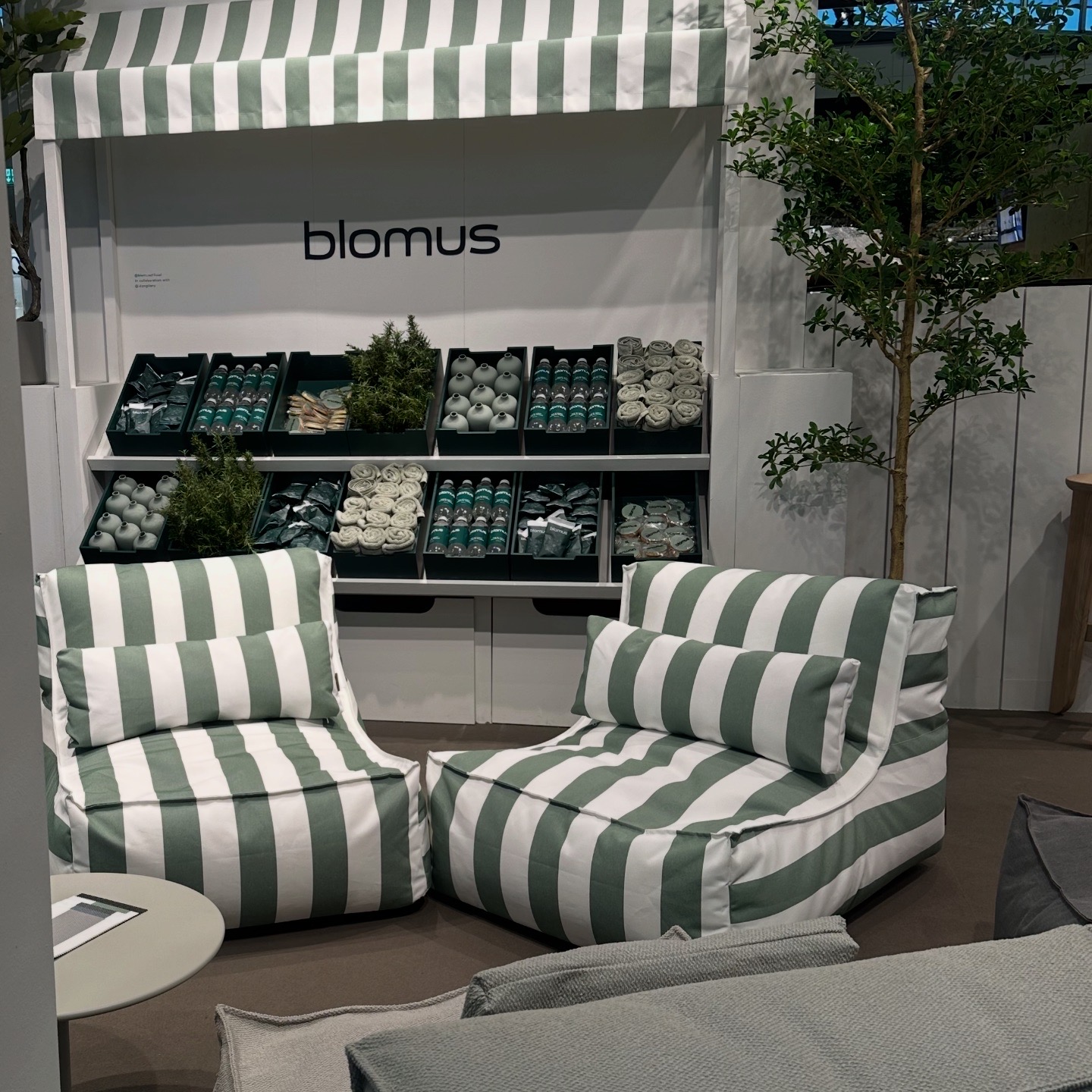 Designmesse mit blomus Stand, gestreiften Loungesesseln und Präsentation von blomus Produkten