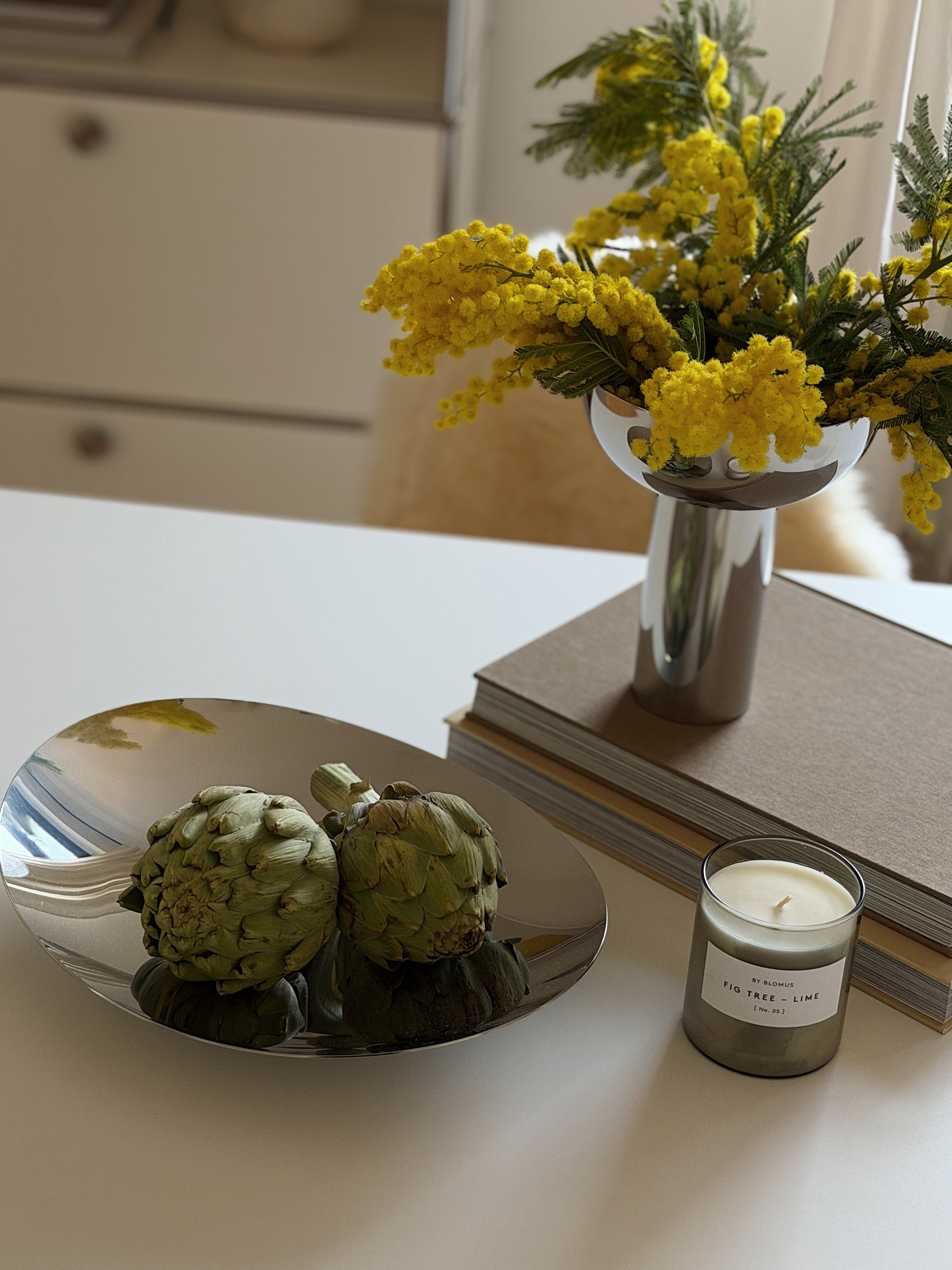 Stilvolle Tischdekoration mit blomus Vase, Frühlingsblumen, Kerze und dekorativer Schale